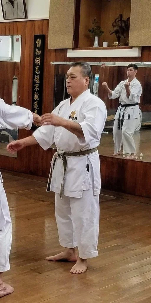 A senior instructor guiding a student through a technique