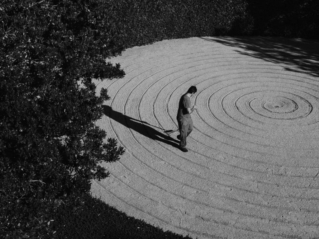 Raked-gravel Zen garden with a lone figure walking