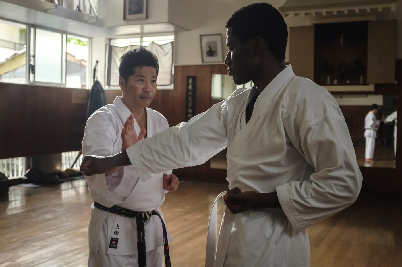 A senior instructor adjusting a student's gi during one-on-one training